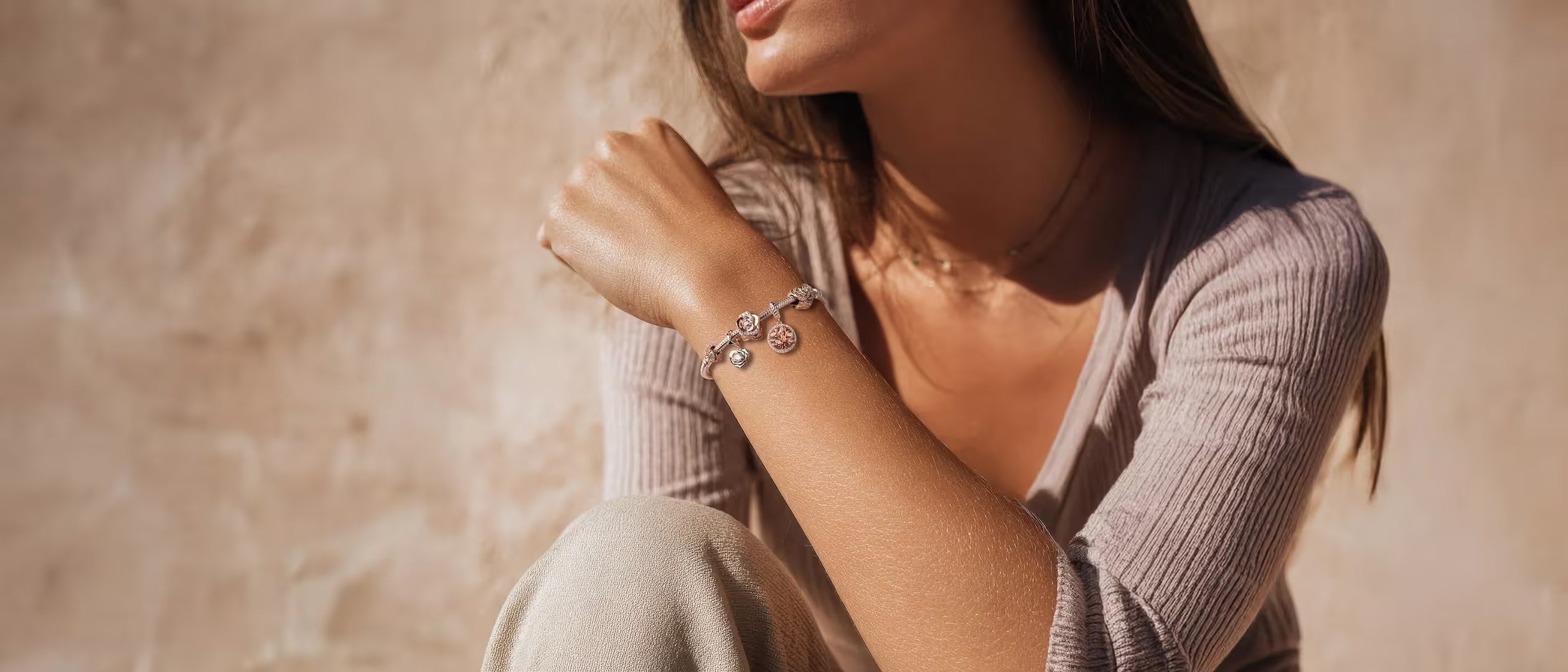 Frau trägt Armband mit Charms Set ROSÉ BLOOM von Charmerie aus 925 Sterling-Silberslider_item_8nTYQg