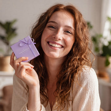 Frau hält Charmerie Geschenkverpackung in der Hand