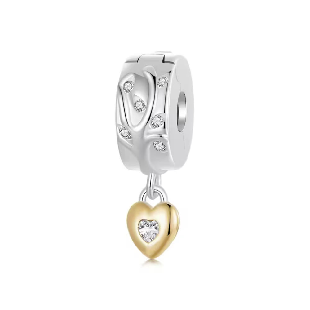 Silberfarbener Charm Clipper mit funkelndem Zweigmotiv und goldenem Herzanhänger mit herzförmigem Zirkonia.