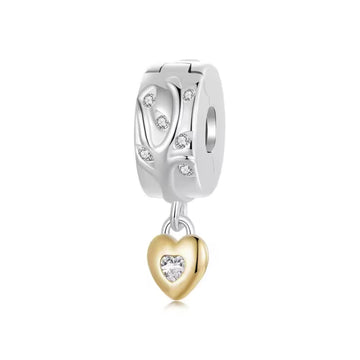Silberfarbener Charm Clipper mit funkelndem Zweigmotiv und goldenem Herzanhänger mit herzförmigem Zirkonia.