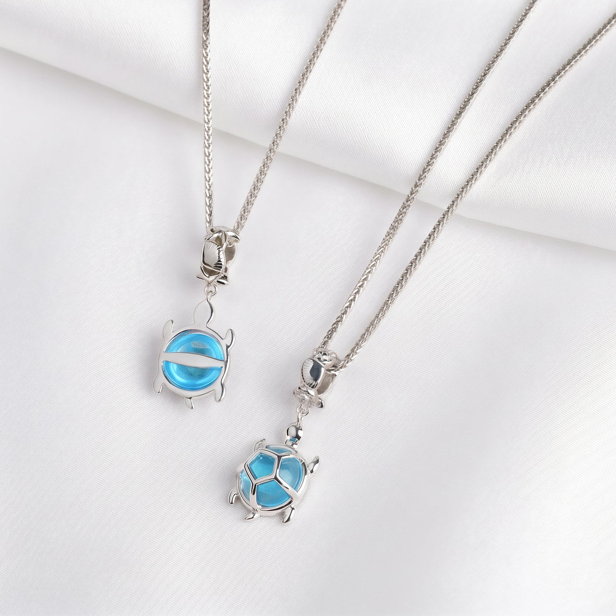 Zwei Ketten mit Schildkröten-Anhängern aus 925 Silber und blauem Kristallglas, Nahaufnahme