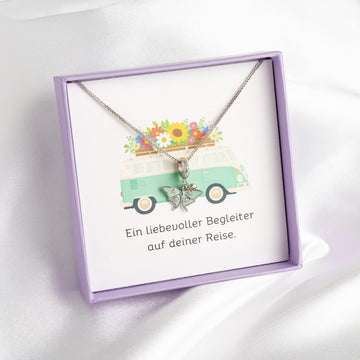 Kette mit mintgrünem Schmetterling-Anhänger aus 925 Silber vor Bulli-Geschenkbox mit Blumenkorb-Motiv