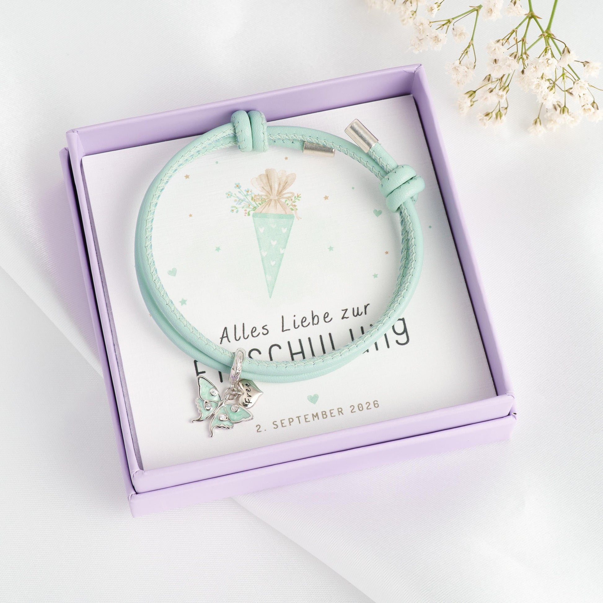 Mintgrünes Lederarmband mit Schmetterling-Charm aus 925 Silber in Geschenkbox, Geschenkkarte "Alles Liebe zur Einschulung" mit Schultüten-Motiv