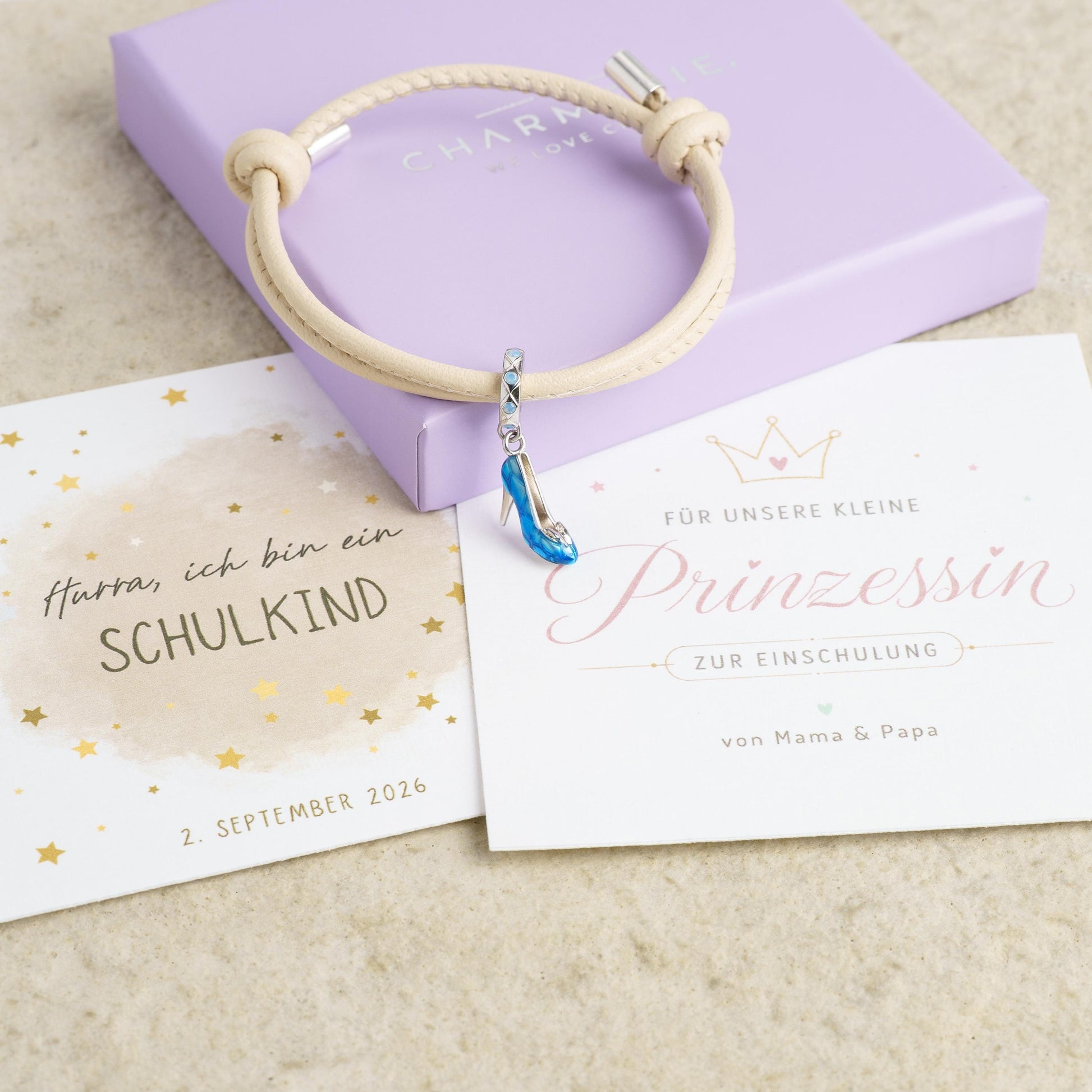 Beiges geflochtenes Lederarmband mit blauem High-Heel-Charm aus 925 Silber in Geschenkbox, Geschenkkarten "Hurra, ich bin ein Schulkind" und "Für unsere kleine Prinzessin zur Einschulung"